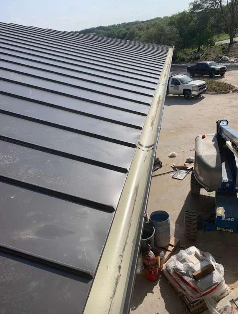 Standing seam panel and gutter detail on a metal roofing jobsite in Peachtree City